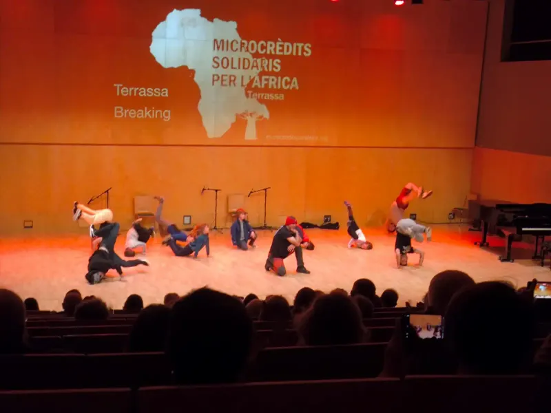 Show de breaking a l'escenari d'un auditori a l'acte Microcrèdits Solidaris per l'Àfrica